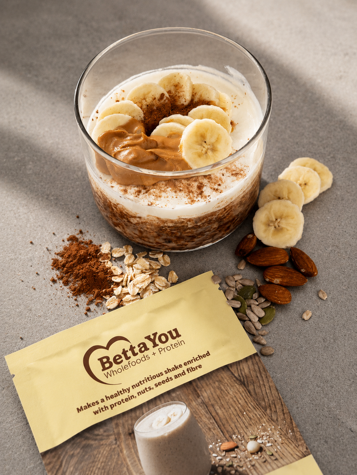 BettaYou chocolate banana overnight oats in a jar topped with banana and peanut butter